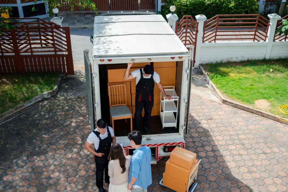 Asian Couple check while unloading boxes and furniture from a pickup truck